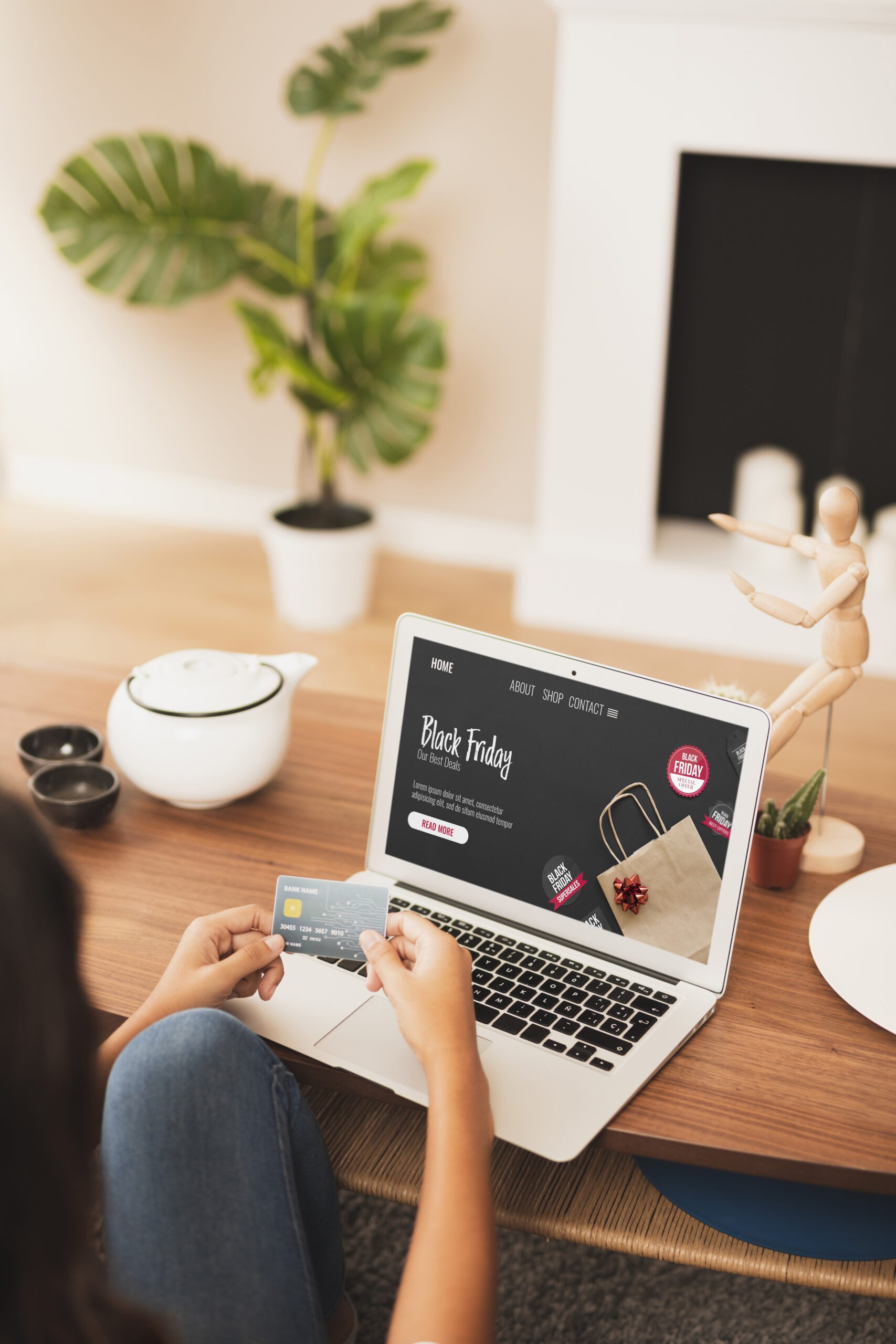 maos segurando um cartao de credito ao lado de um laptop mock up